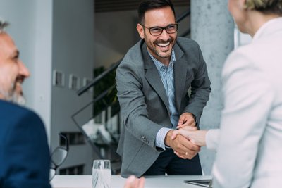 Meeting bei dem Mann einer Frau die Hand schüttelt