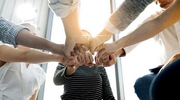 6 Arme mit mit geballter Faust aneinander